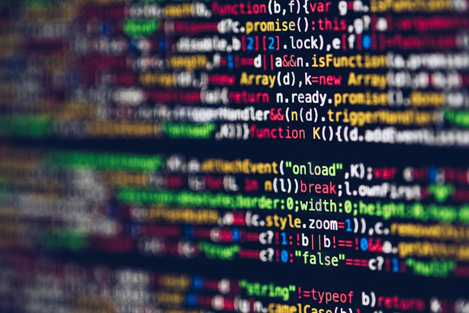 Close-up image of a computer screen displaying a blurred code editor with multicolored programming code, including functions, variables, and commands in various colours such as red, blue, green, yello
